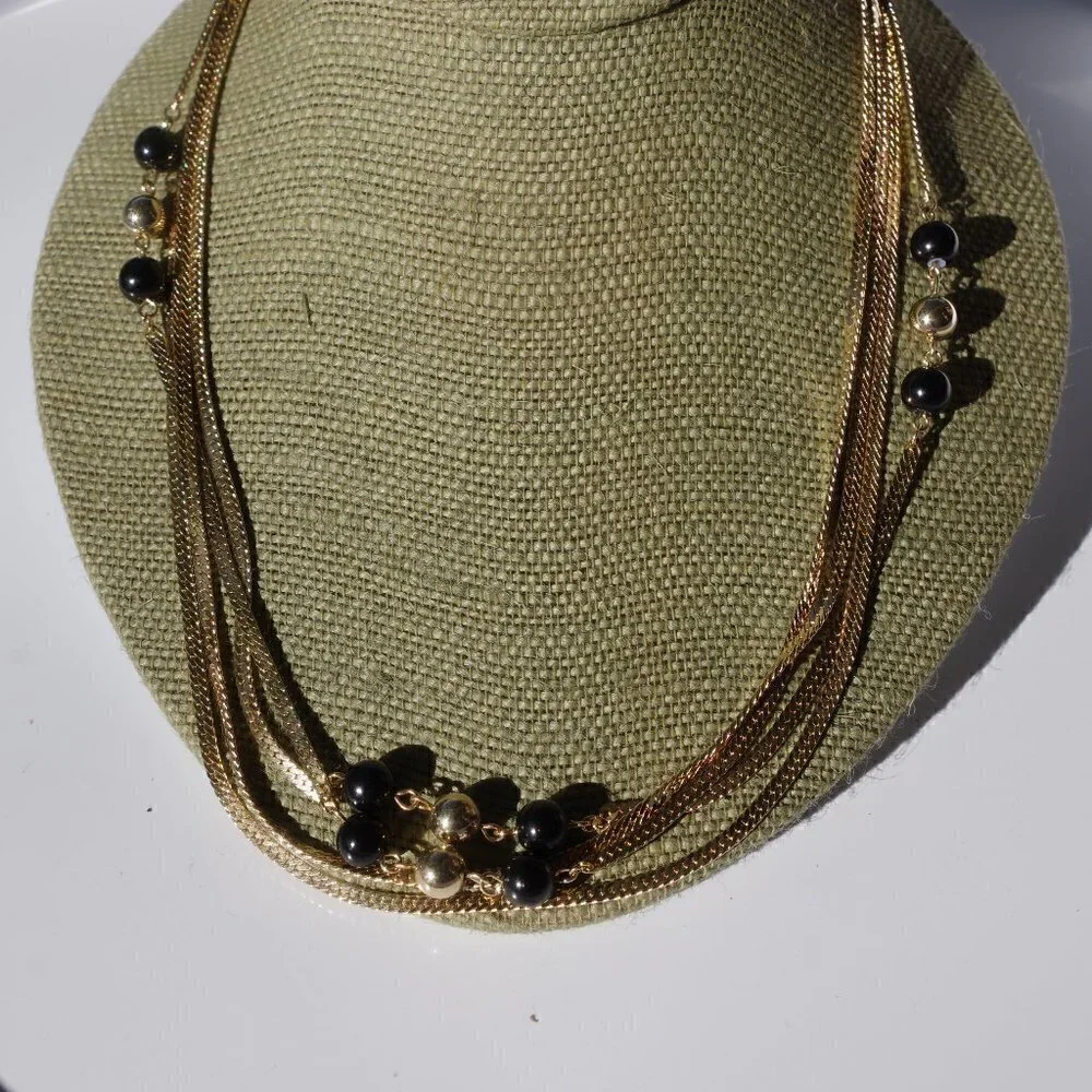Women`s gold tone black/gold bead chain necklace.